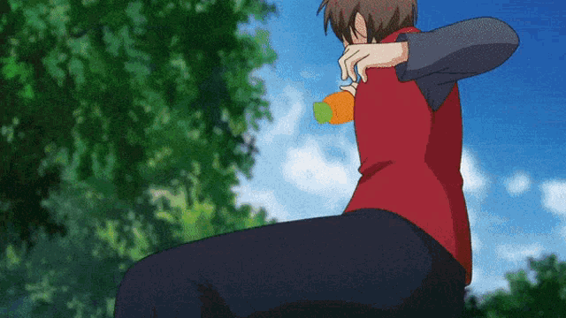 a man in a red shirt is holding an orange bottle