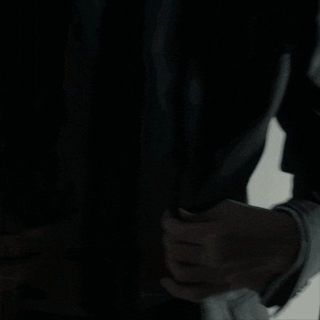 a man in a suit and tie is standing in a dark room