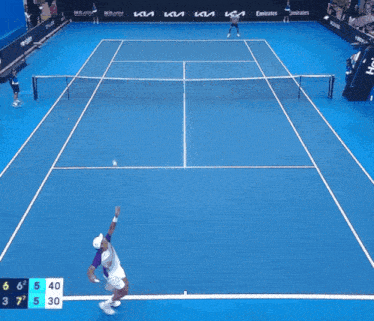 a tennis match is being played on a blue court with emirates advertisements