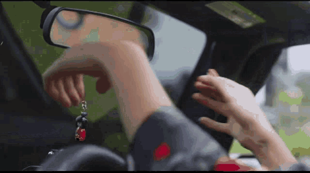 a person putting a key in the rear view mirror