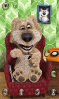 a talking dog is sitting in a red chair with a toothbrush and a picture of a cat on the wall .