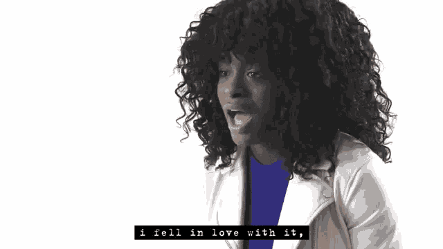 a woman with curly hair and a white jacket says " i fell in love with it "