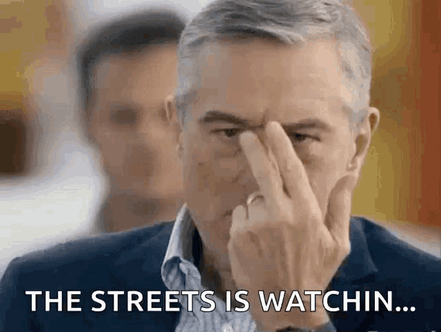 a man with his finger on his forehead says the streets is watchin ..