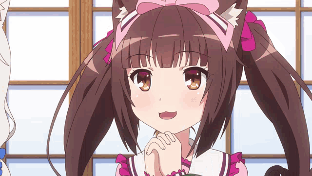 a girl with brown hair and a pink bow on her head looks at the camera
