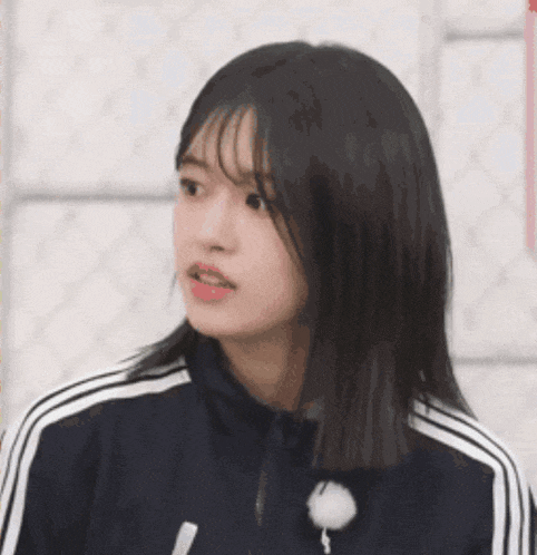 a close up of a girl wearing a blue jacket with white stripes on the side .