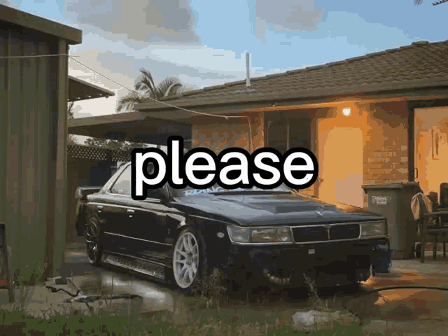 a black car is parked in front of a house and the word please is written above it