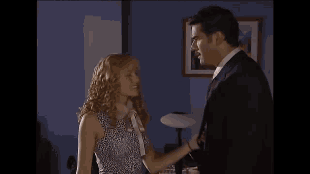 a man in a suit and tie is holding a woman in a dress .