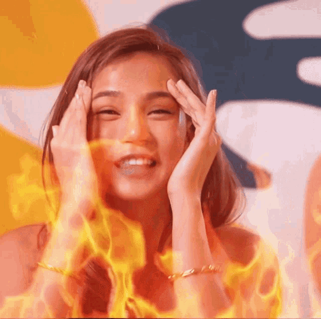 a woman with flames coming out of her face is smiling