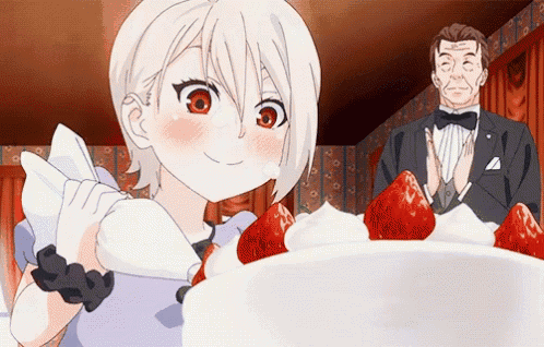 a man in a tuxedo stands in front of a cake with strawberries on top