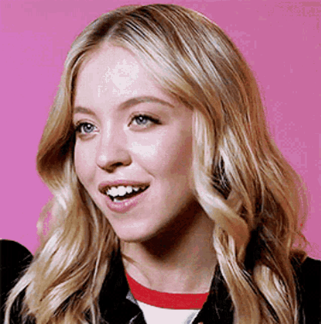 a close up of a woman 's face on a pink background with her mouth open