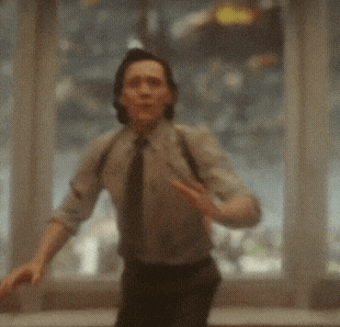 a man in a suit and tie is standing in front of a window making a funny face