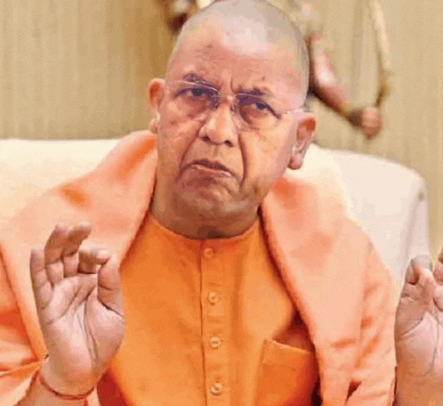 a bald man wearing glasses and an orange shirt is sitting on a couch .