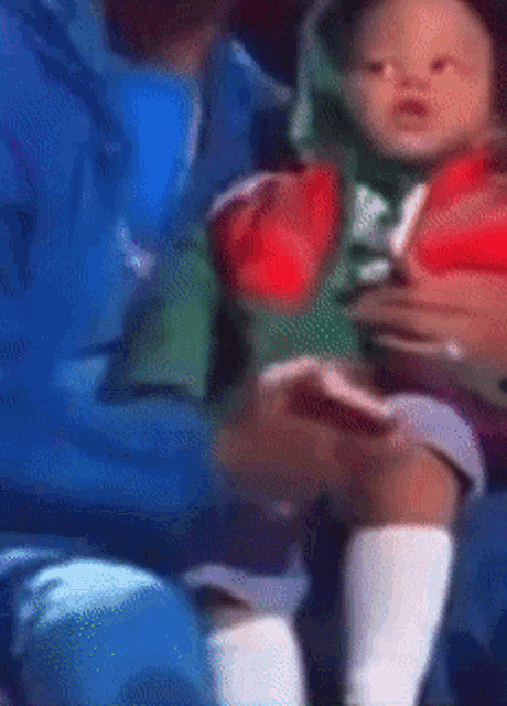 a blurry picture of a man holding a baby in his arms