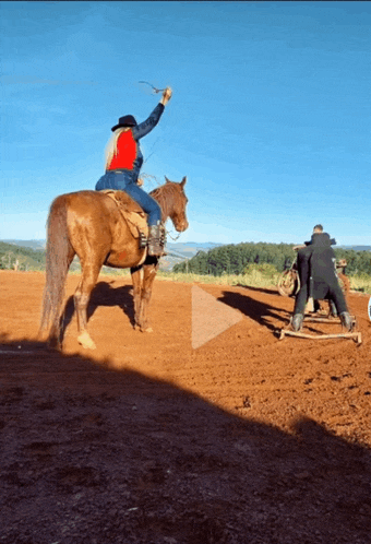 a woman is riding a brown horse in a field