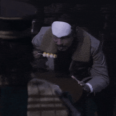 a man with a bandage on his forehead is holding a skewer of food