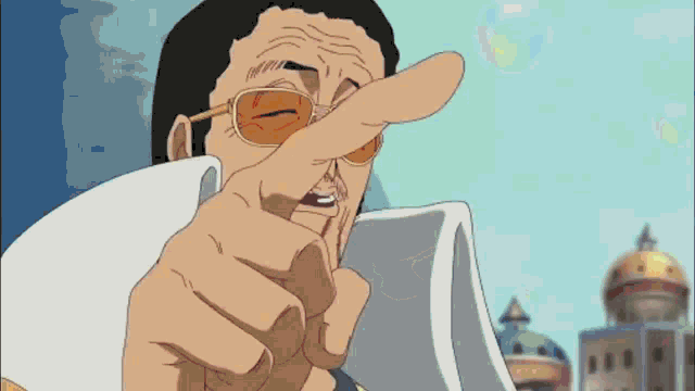 a man wearing sunglasses is pointing his finger at something .