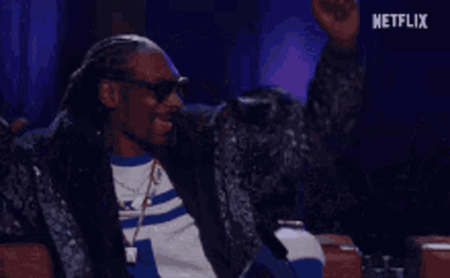 snoop dogg is sitting in a chair with his arms outstretched in a netflix advertisement .