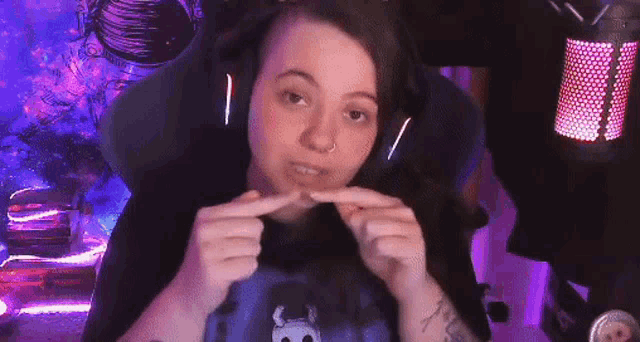 a woman wearing headphones is sitting in front of a microphone .