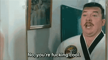 a man in a karate uniform is looking at himself in the mirror and saying no , you 're fucking cool .