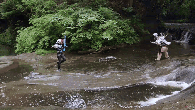 a man in a wet suit is standing in a stream