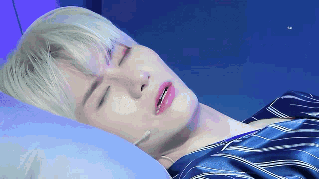 a close up of a person laying on a bed with their eyes closed and the letters jm visible in the corner