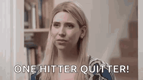 a woman is saying `` one hitter quitter '' while standing in front of a bookshelf .