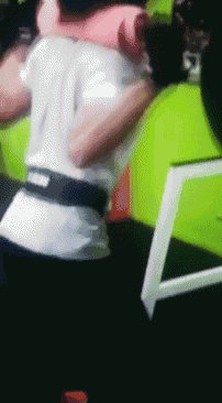 a man in a white shirt and black belt is hugging another man