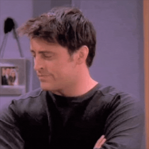 a close up of a man 's face with his arms crossed and a picture in the background .