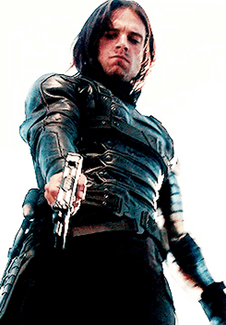 a man in a leather jacket holds a gun in his right hand