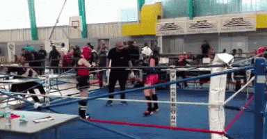 a referee stands in a boxing ring with a sign behind him that says ' no seson '