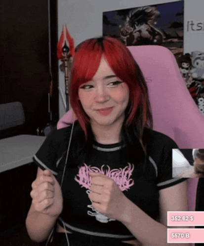 a girl with red hair is sitting in front of a pink chair with a sign that says its