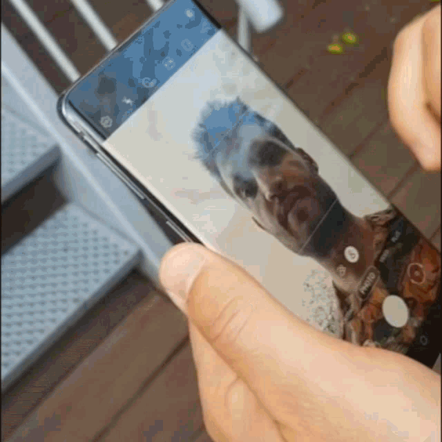 a person is taking a picture of a man 's face on a phone