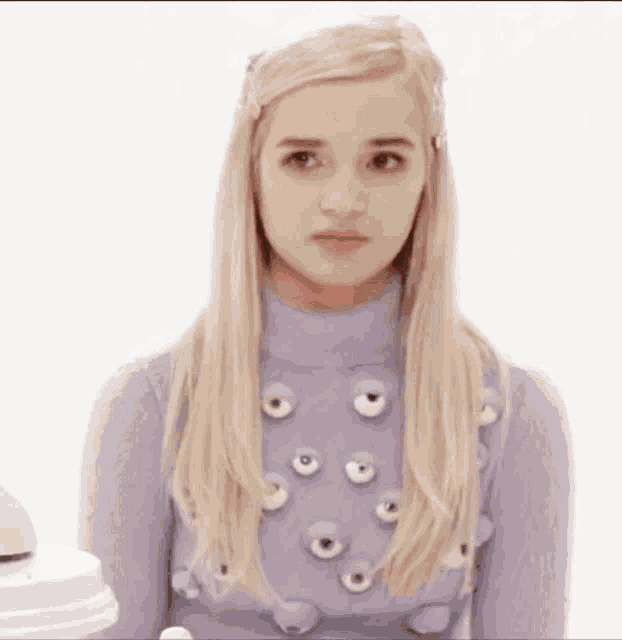 a woman in a purple sweater with eyes on it