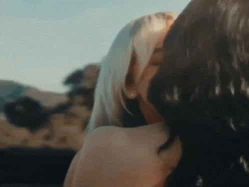 a couple of women are kissing each other in a car .