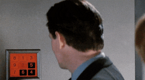 a man in a suit is looking at a keypad with numbers like 8 1 3 and 5 on it