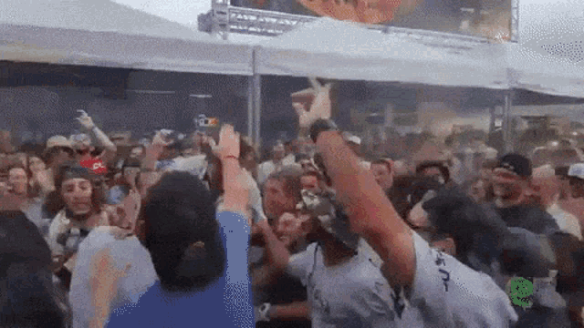 a crowd of people are dancing in front of a sign that says ' nbc '