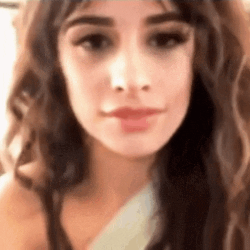 a close up of a woman 's face with long curly hair .