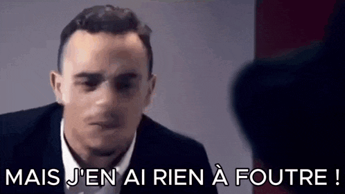 a man in a suit and tie is talking to another man in a room .