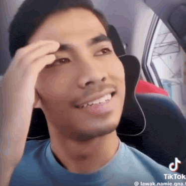 a young man is sitting in the back seat of a car .