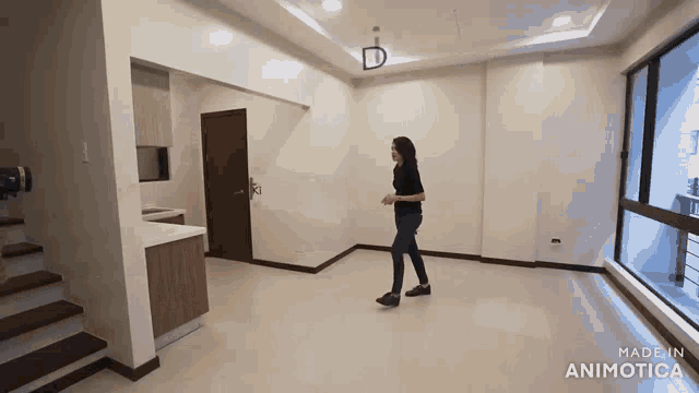 a woman is standing in an empty room with the words made in animotica on the bottom