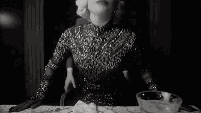 a black and white photo of a woman in a sequined dress