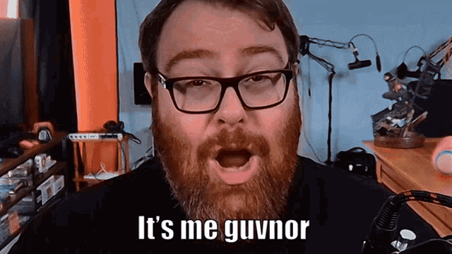 a man with a beard wearing glasses says it 's me guvnor