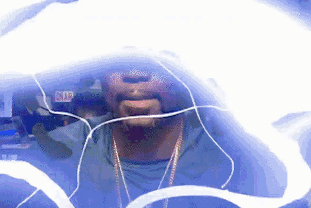 a man wearing ear buds is surrounded by a blue light and a sign that says onair