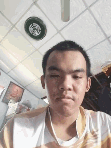 a young man taking a picture of himself with a ceiling fan behind him