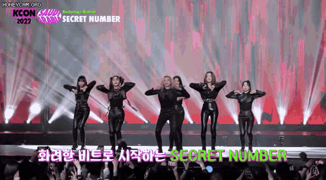 a group of women are dancing on a stage with the words secret number written on it