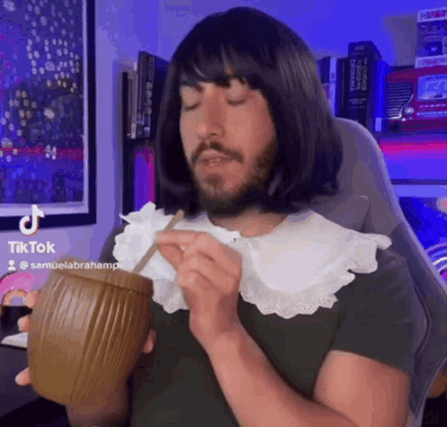 a man wearing a wig and a collar is drinking from a cup