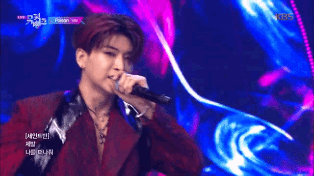 a man singing into a microphone with kbs on the bottom