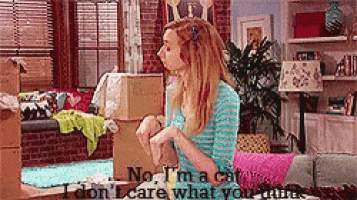 a woman is sitting on a couch in a living room holding a cardboard box .