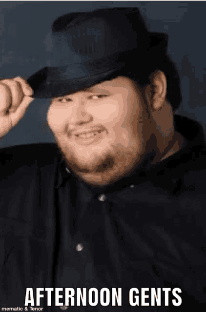 a man with a beard is wearing a fedora and smiling .