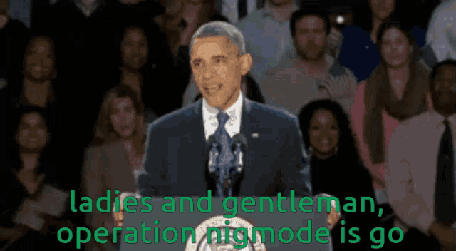 a man in a suit and tie stands in front of a crowd and says " ladies and gentleman operation niigmode is go "